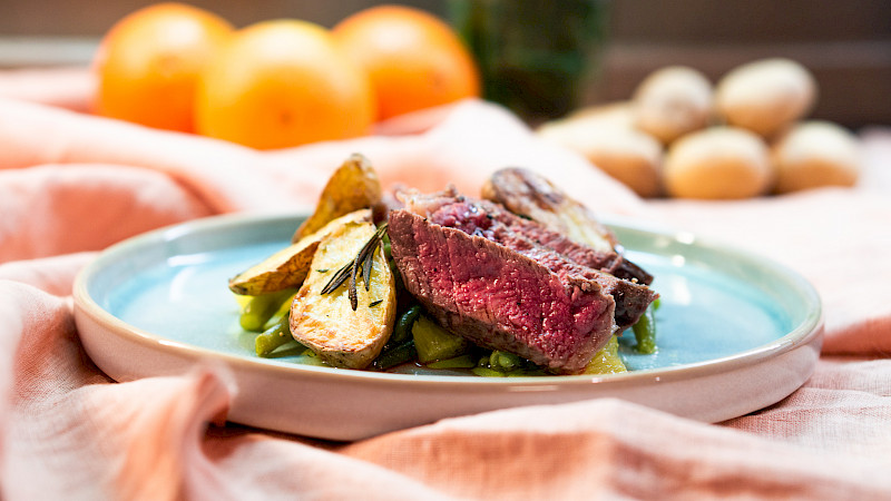 Entrecôte mit Ofenkartoffeln auf grünen Bohnen und Orangen